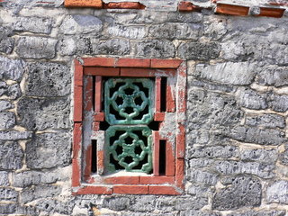 用紅磚砌成窗戶，安上青瓷花窗，牆身都是玄武岩石塊當建材，可見這戶人家以前小有積蓄