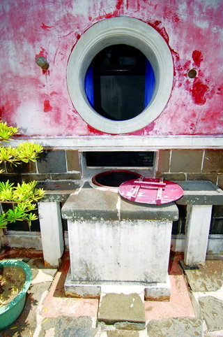 石製水缸一半露出於天井，一半嵌入廚房，便利於天井與廚房內工作的家人取水