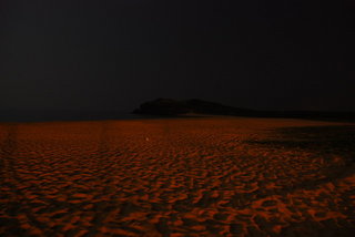 夜色下的山水沙灘，有月亮的夜晚會十分明亮，海水反射約光宛如沙灘被一盞超大暈黃燈光照映著