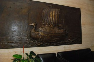 商務中心牆壁上懸掛的銅雕帆船圖樣